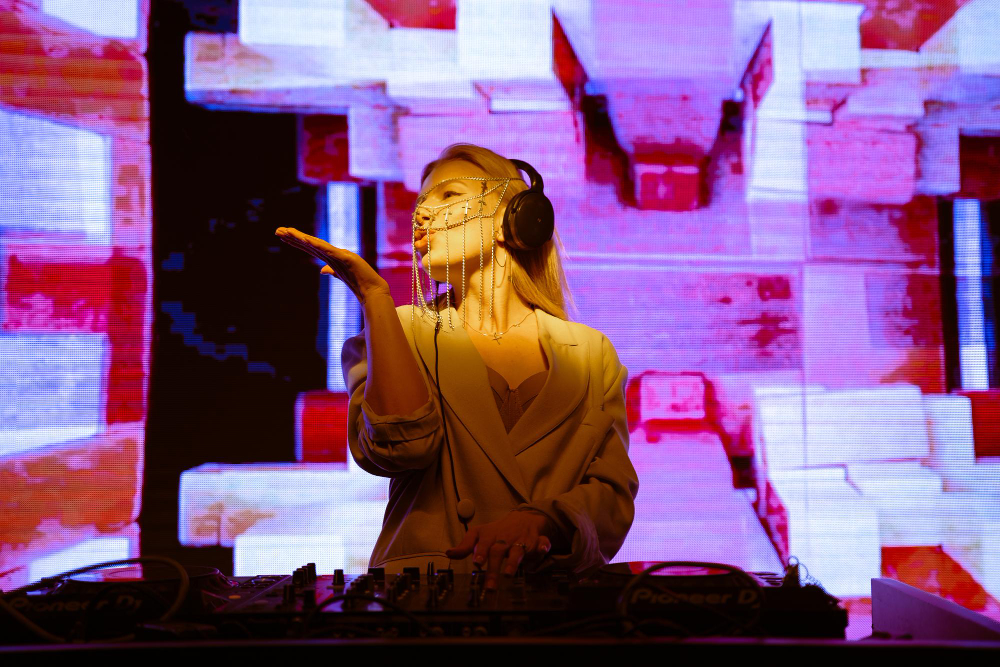 Audio-reactive visuals playing on an LED wall behind a solo DJ